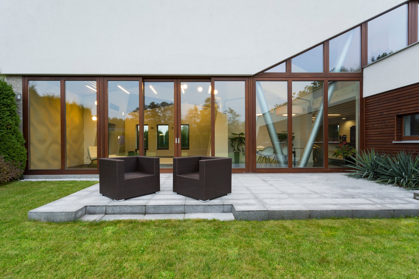Ascetic villa patio with rattan chairs and grey floor